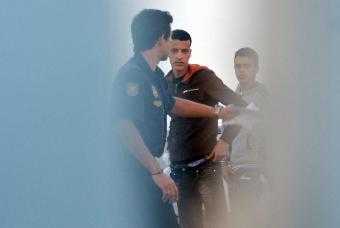 Un polica custodia a dos inmigrantes en Fuerteventura. Fuente: El Pas
